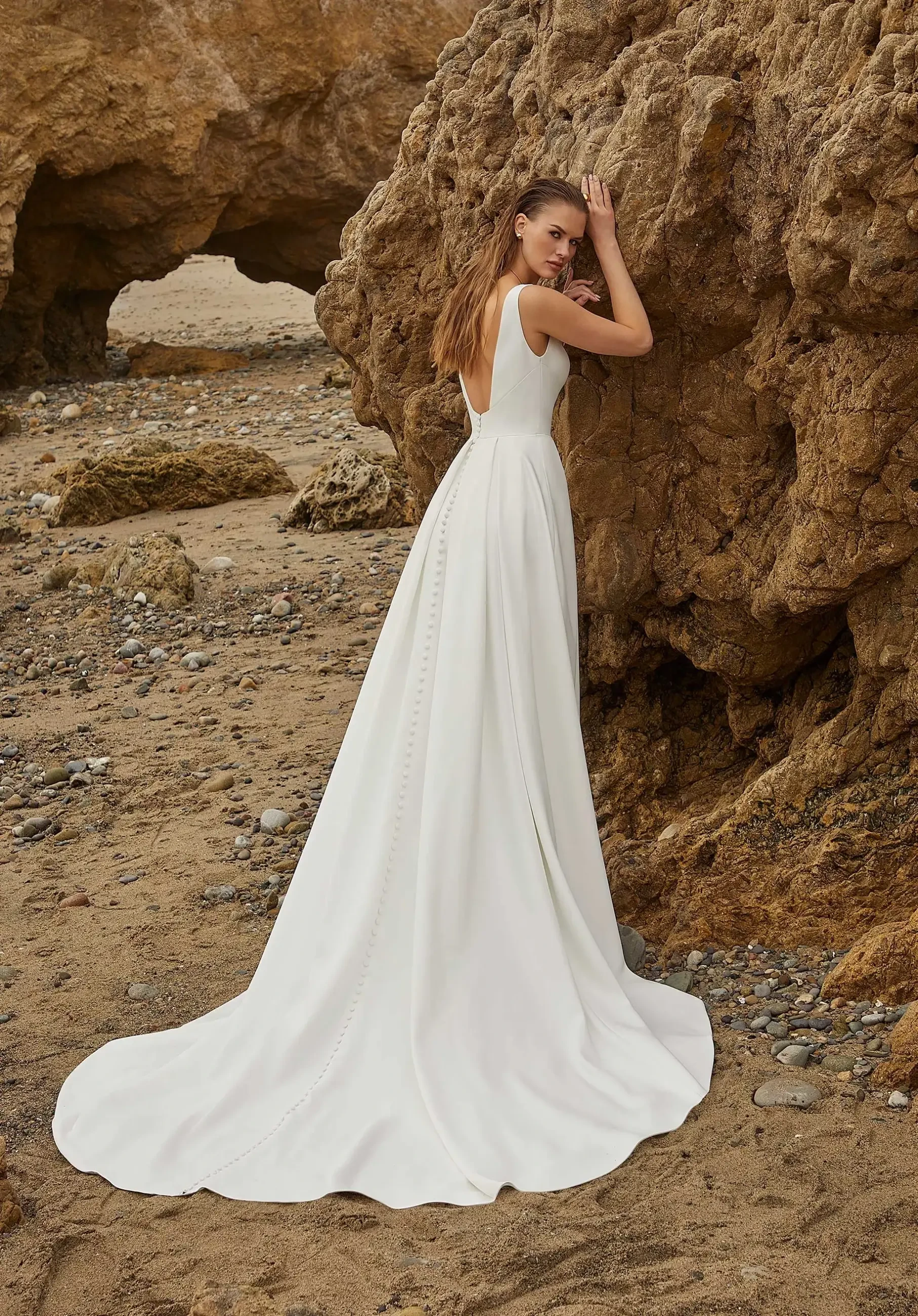 Model is wearing a Luxe satin A-line dress with a plunging neckline, corset-style seams, and a soft pleated skirt.