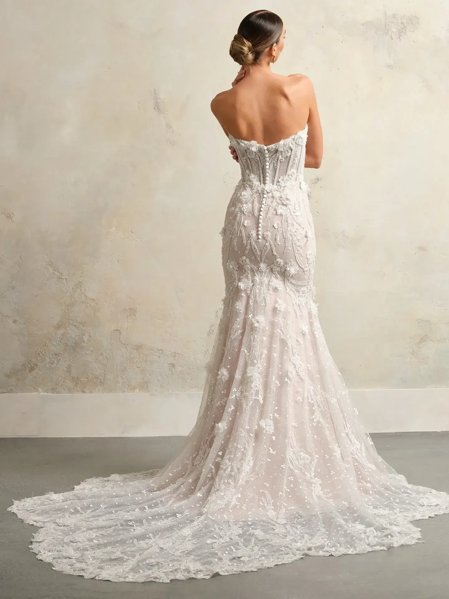 model is wearing a strapless mermaid wedding dress with 3d floral appliques and detachable optional sleeves