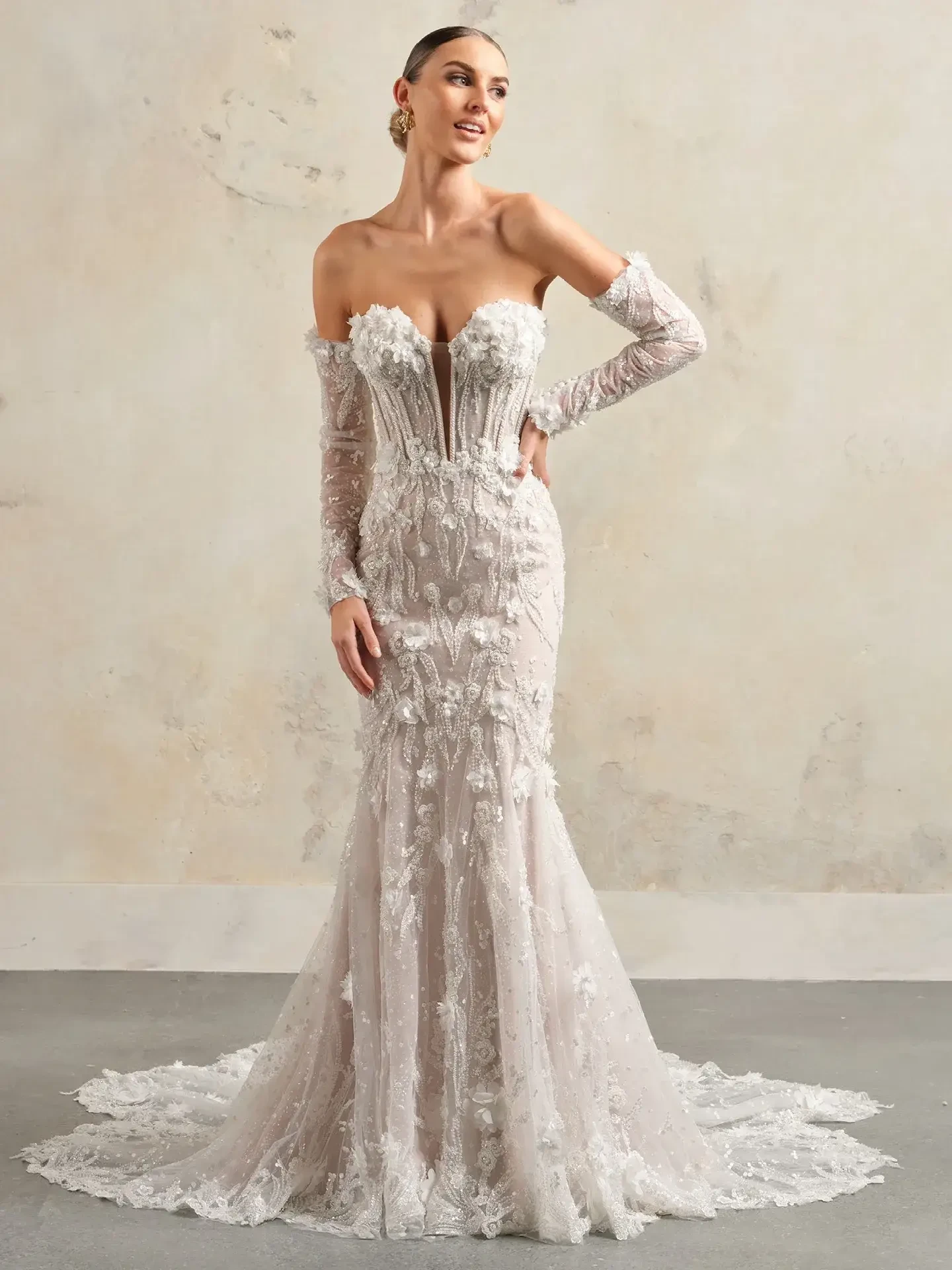 model is wearing a strapless mermaid wedding dress with 3d floral appliques and detachable optional sleeves