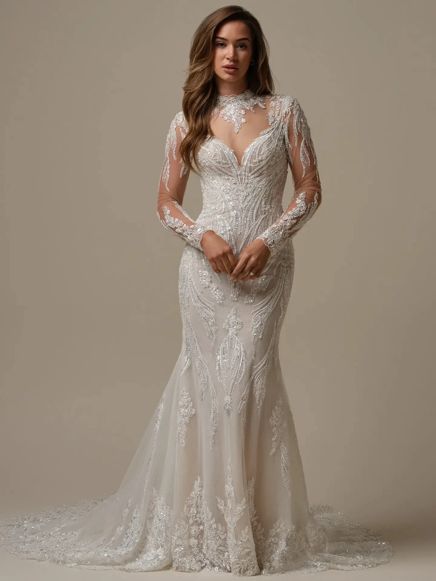 A woman wearing an elegant, long-sleeved wedding dress with intricate lace detailing and a fitted silhouette. The dress has a deep neckline and a flowing train, lending it a sophisticated and romantic appearance.