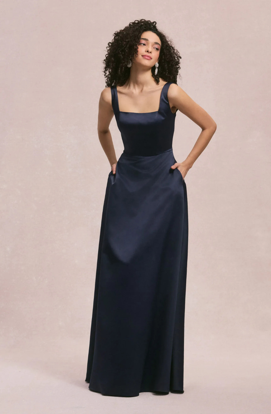 model is wearing a sleeveless black bridesmaid dress