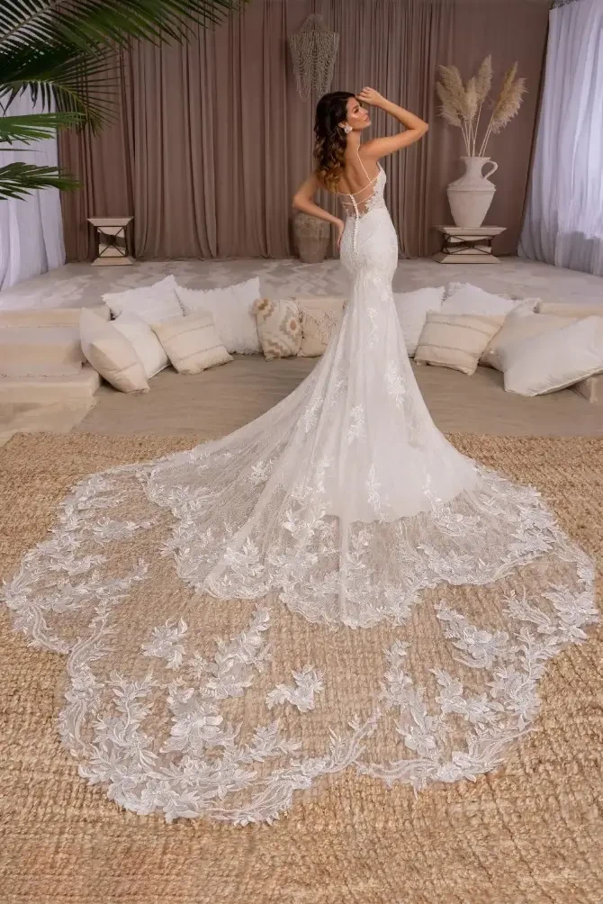 Model is wearing a fit and flare bridal dress with a plunging neckline and spaghetti straps from kitty chen