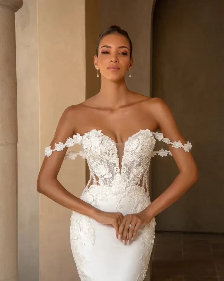 Model is wearing a fitted wedding dress with plunging neckline and lace straps by kitty chen