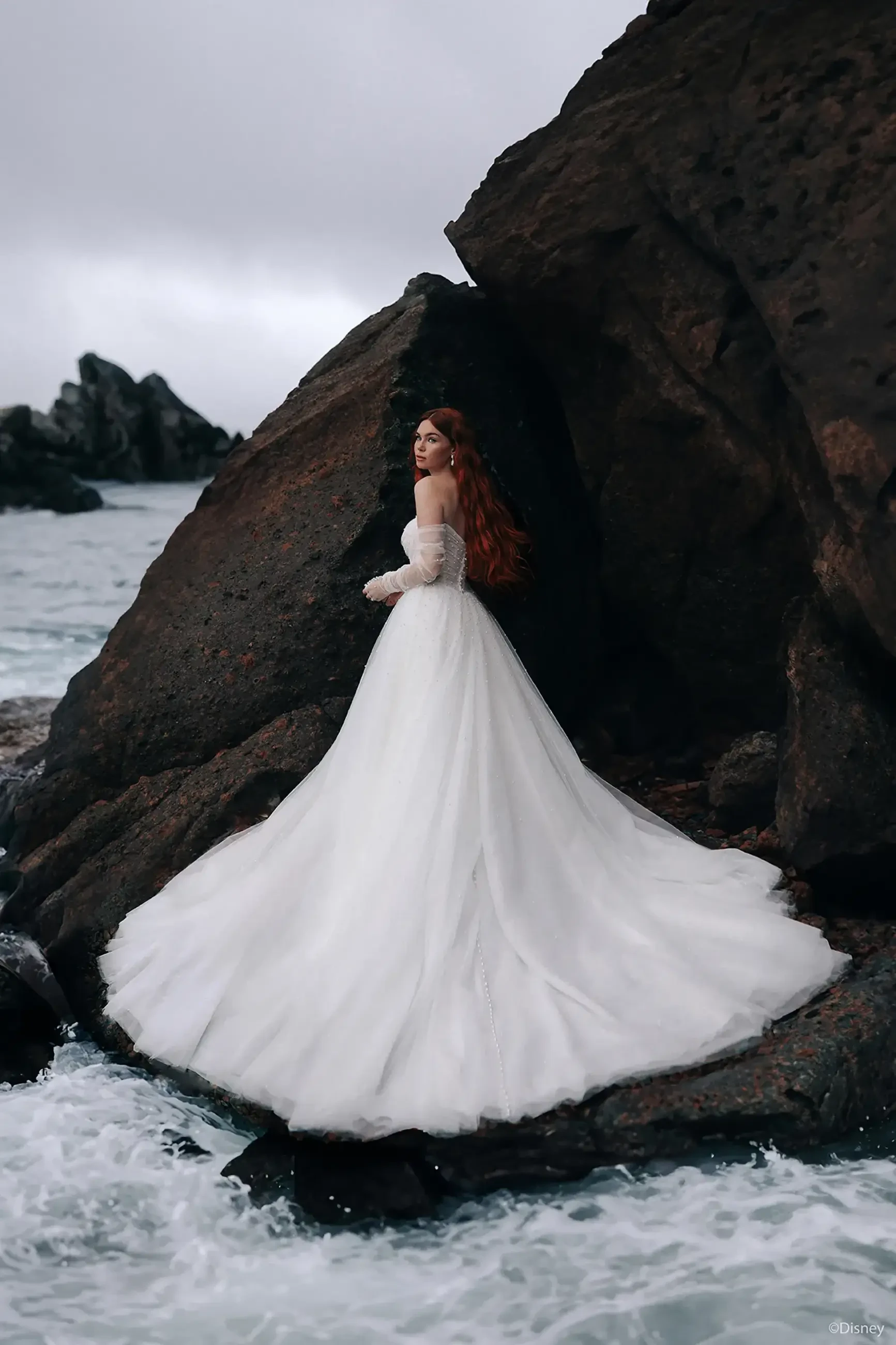 model is wearing an a-line wedding dress with a long train