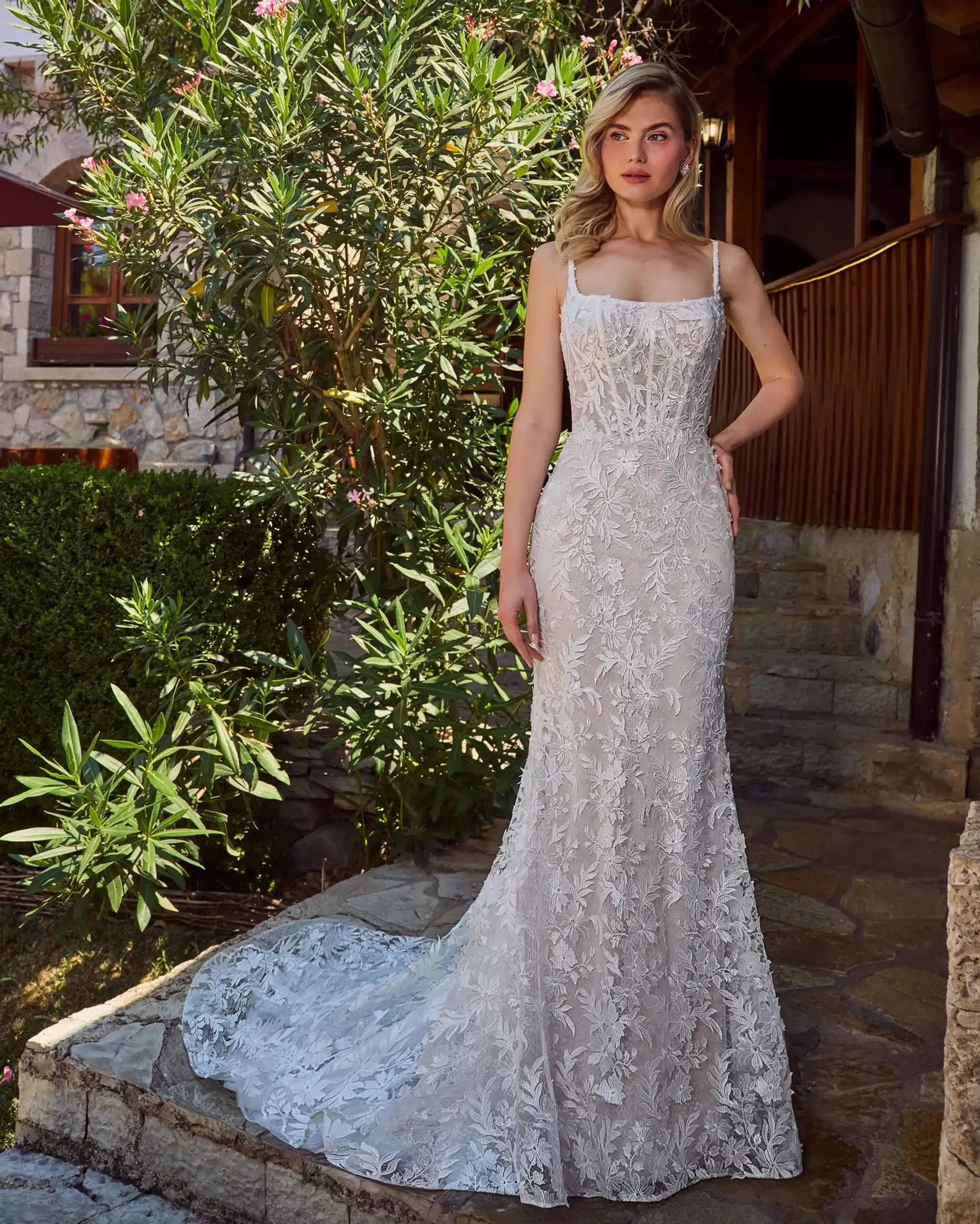model is wearing a sleeveless floor length spaghetti strap bridal gown