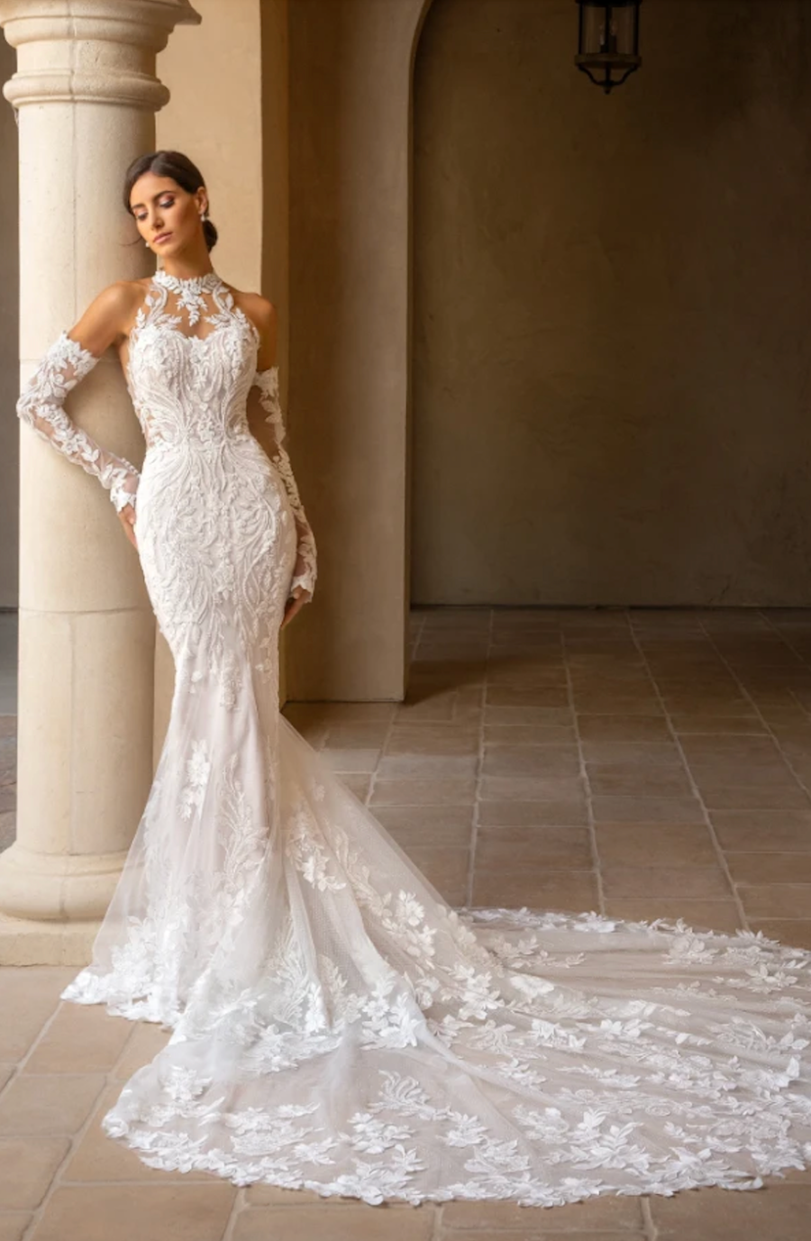 model is wearing a glamorous lace fit and flare bridal dress